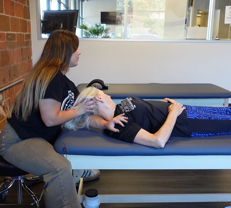 Relaxed patient receiving hands-on care on a treatment table at Rausch PT & Wellness
